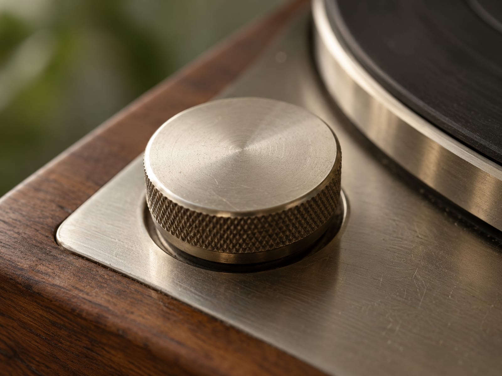 Close-up of a vintage turntable speed selector knob with a smooth unmarked face in warm light